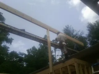 Carpenter setting a ridge beam over a new addition frame — Ice Dam Removal by Roofing Brothers in Carroll
