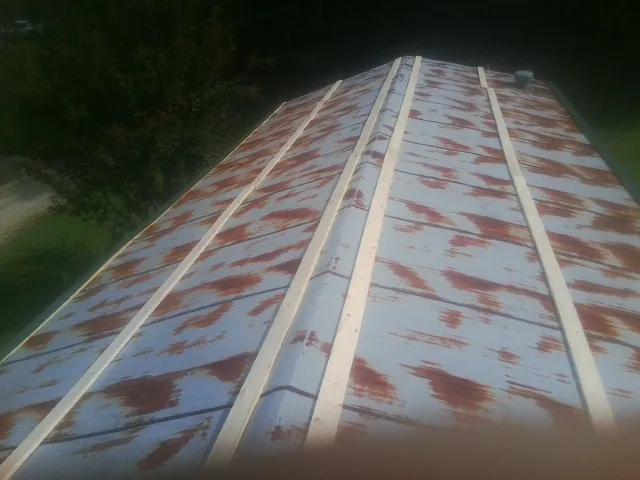 Rusted metal roof panels with new wood purlins before replacement — Storm Damage Roof Repair in Carroll by Roofing Brothers